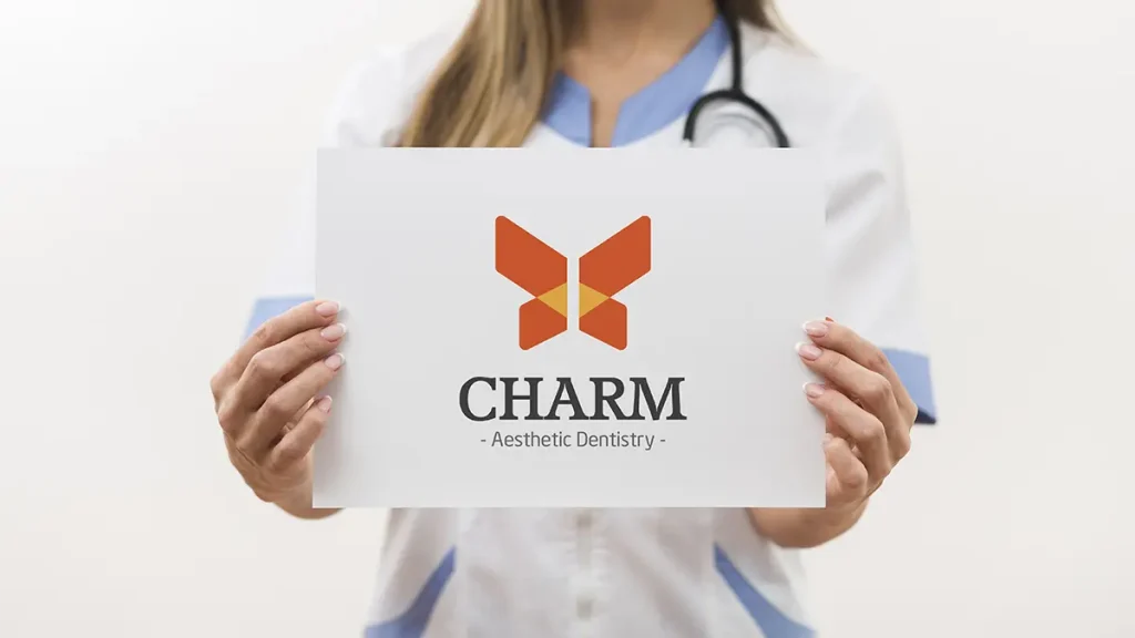 Charm aesthetic dentistry logo on white background featuring a stylized butterfly symbol with warm orange and soft yellow tones above the Charm wordmark